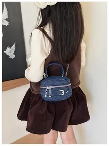Close-up of quilted denim texture on a mini crossbody bag with silver buckle details