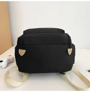 Detail eines schwarzen Segeltuchrucksacks mit beigen Reißverschlüssen in Herzform