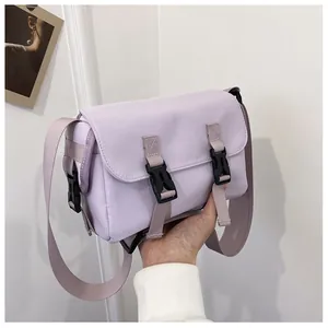 Detail view of the lavender canvas messenger bag with double black plastic buckle closures