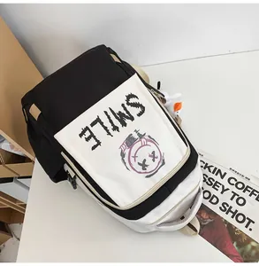 Detail eines schwarz-weißen Rucksacks mit SMILE-Graffiti und Enten-Anhänger
