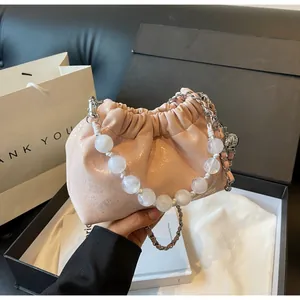 Detailaufnahme der rosa gerafften Cloud-Bag mit Perlengriff und Lederkettenriemen
