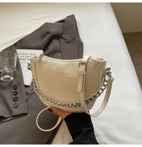 Detail of creamy pleated hobo bag with silver chain strap and minimalist design