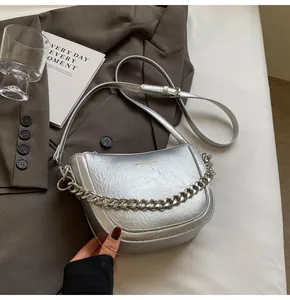 Detailed view of silver pleated texture and chunky chain on the stylish crossbody bag