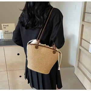 Detailed view of woven straw bag featuring brown leather trim and drawstring canvas liner