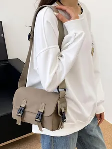 Minimalist khaki messenger bag with double buckle closure and adjustable nylon strap