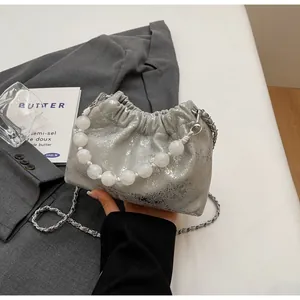 Detailansicht der silbernen Plissee-Wolken-Tasche mit großem Perlenriff und Metallkette