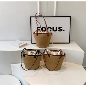 Three handwoven bucket bags with canvas drawstring liners in black and brown leather trim