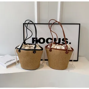Detail of woven straw bucket bags with leather trim and drawstring closure for vacation
