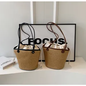 Detail of woven straw bucket bags with leather trim and drawstring canvas lining