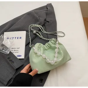 Detail der mintgrünen Kordelzug-Beuteltasche mit großem Perlengriff und Silberkette