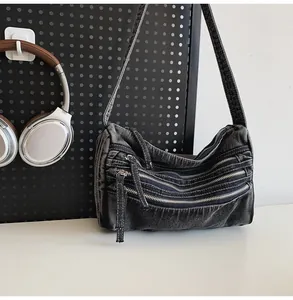Λεπτομέρεια vintage μαύρης τζιν τσάντας με τρία μεταλλικά φερμουάρ στην μπροστινή πλευρά