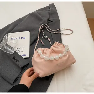 Detail der hellrosa Cloud-Bag mit Perlengriff und silberner Fashion-Aufschrift