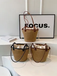 Three hand-woven straw bucket bags with drawstring liners and slim leather shoulder straps