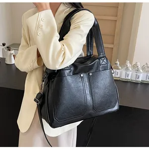 Detail of vintage black faux leather tote with textured grain and silver rivet accents