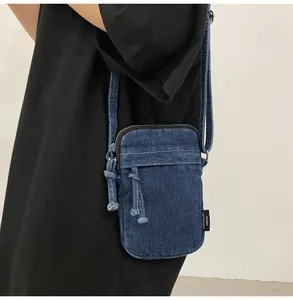 Λεπτομέρεια της σκούρας μπλε τσάντας τζιν χιαστί φορεμένη στον ώμο