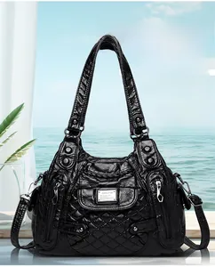 Detail view of black quilted faux leather handbag with silver metallic logo and zippers