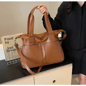 Detail view of vintage brown tote bag showing rivet accents and adjustable shoulder strap