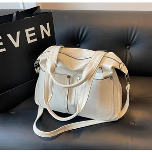 Macro detail of creamy white tote bag with textured PU leather and silver metal studs