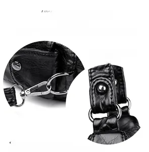 Close-up of polished metal lobster clasp and hardware on a black pebble leather bag