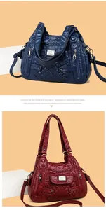 Detail of multi-pocket soft leather bags with quilted stitching in navy and burgundy