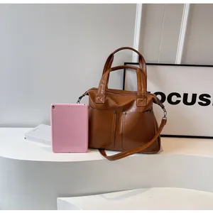 Brown faux leather tote bag showing large capacity with a tablet size comparison