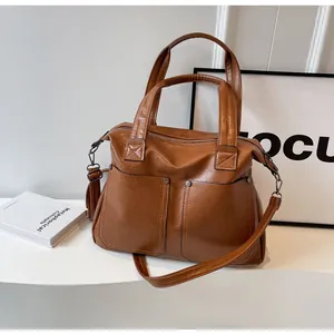Close-up of caramel retro tote bag showing soft leather texture and rivet details