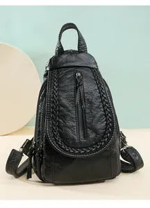 Detail of vintage black pleated leather backpack with woven edges and tassel zipper