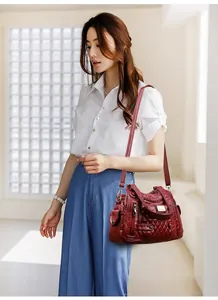 Detailed view of the wine red soft leather handbag with multiple zipper pockets