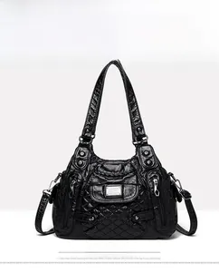 Close-up of black quilted leather shoulder bag featuring silver zippers and dual handles