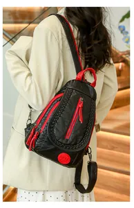 Detail of soft leather backpack with red zippers and woven texture on stairs