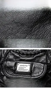 Macro view of black litchi texture leather and JING PIN metal brand plaque on bag