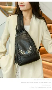 Detail of vintage black leather bag featuring floral embroidery and woven trim edges