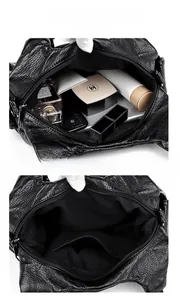 Macro shot showing internal pockets and large storage capacity of a black soft leather bag