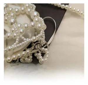 Détail du fermoir mousqueton en métal argenté sur un sac à main en perles artisanales