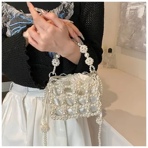 Détail du sac à main en perles avec pochette en satin et anse élégante en perles blanches