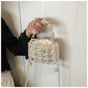 Détail du sac à main en perles fait main avec doublure en satin et poignée arrondie