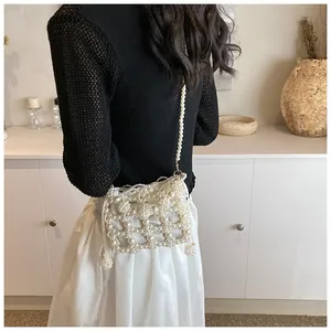 Gros plan d'un sac bandoulière en perles crème fait main avec texture de perles tissées
