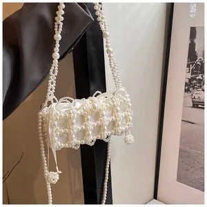 Détail du sac à main en perles blanches avec doublure satinée et bandoulière
