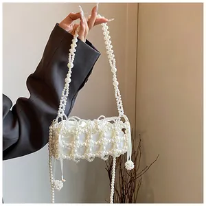 Détail d'un sac à main en perles blanches fait main avec doublure en satin et sangle