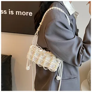 Détail d'un sac à perles blanches avec doublure satinée et texture à losanges