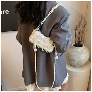Détail d'un sac à main en perles blanches fait main avec une doublure en satin doux
