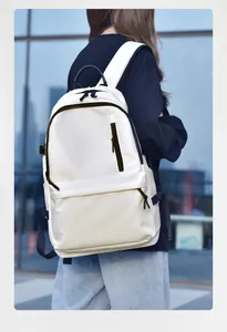 Detail of a minimalist white leather backpack with multiple black zipper pockets