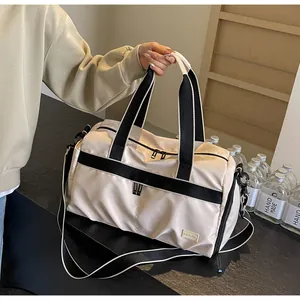 Detail einer großen cremefarbenen Reisetasche mit schwarzen Gurten und Metall-Zippern