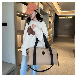 Close-up of beige water-resistant travel bag with black straps in a library setting