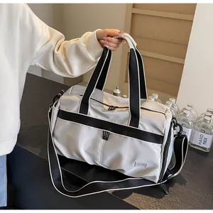Detailansicht der grauen Reisetasche mit schwarzen Gurten und gewebten Griffen