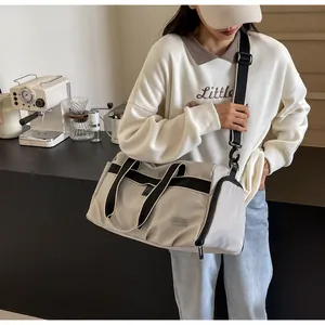 Detail der grauen Nylon-Sporttasche mit schwarzen Griffen in einem modernen Café