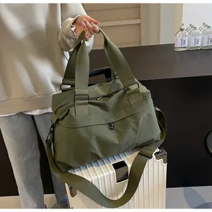 Details der armeegrünen Reisetasche auf dem Koffer mit verstärkten Griffen und Schultergurt