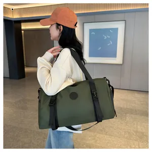 Detail of army green travel bag featuring black nylon straps and adjustable side buckles