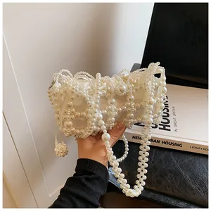 Détail d'un sac à main en perles blanches fait main avec doublure en satin et bandoulière