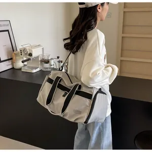 Nahaufnahme der grauen Reisetasche mit Nylon-Textur und verstellbarem Schultergurt